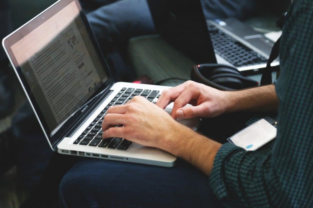 man typing on a laptop