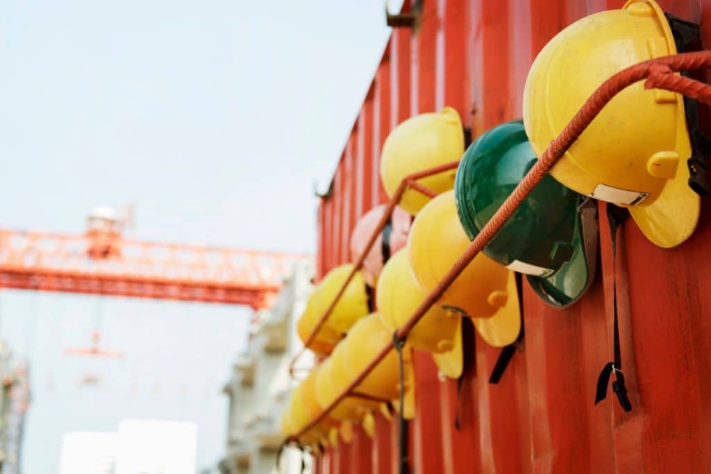 workers hard hats strapped to a container
